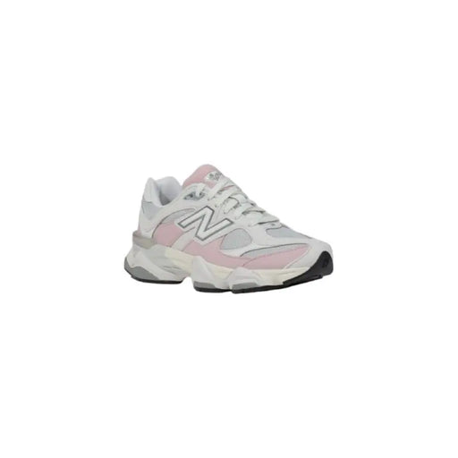 Pink and white New Balance sneaker displayed in a product image
