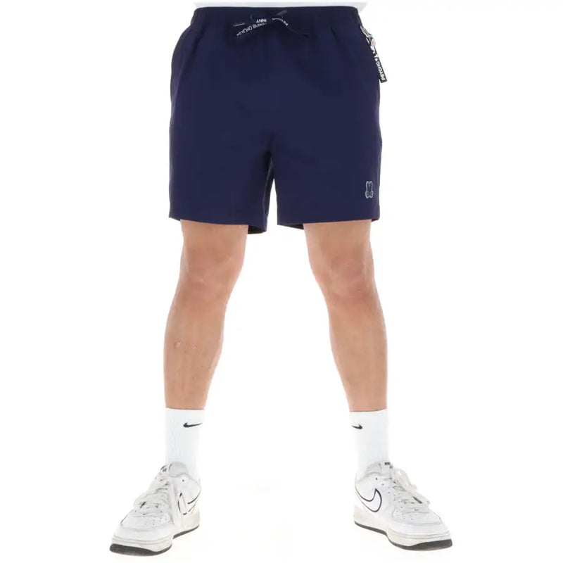 Short de bain homme Psycho Bunny bleu marine en polyester, avec ceinture à cordon, poches et logo blanc sur le bas de la jambe.