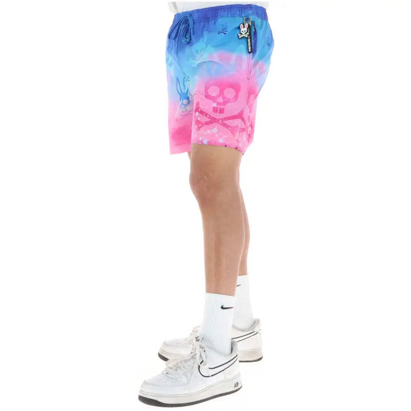 Psycho Bunny men swimwear vibrant gradient swim trunks with bold pink and blue skull graphic and white bunny accents