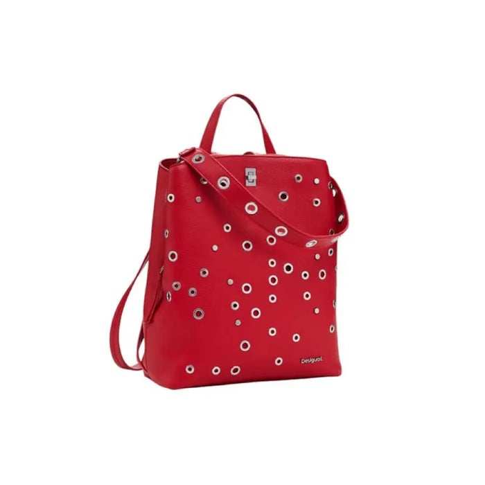 Red faux leather backpack with silver eyelets displayed in a stylish product photograph