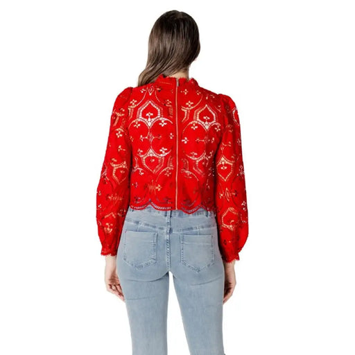 Red lace long-sleeve blouse paired with light blue jeans, fashionable and elegant attire