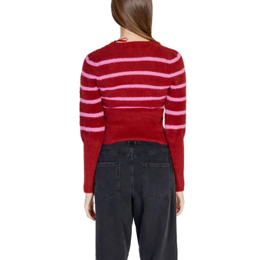 Red and pink striped Women’s Round Neck Sweater paired with dark jeans