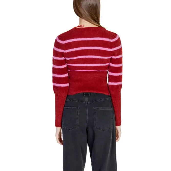 Red and pink striped Women’s Round Neck Sweater paired with dark jeans
