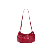 A glossy red polyester handbag with a gathered top and slender shoulder strap by Desigual