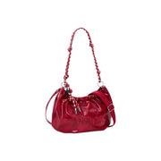 A glossy red polyester handbag by Desigual with braided shoulder strap and adjustable side handle