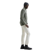 Pull en coton Replay pour homme, vert olive côtelé, col zippé, porté par le mannequin avec un pantalon blanc et des bottes noires.