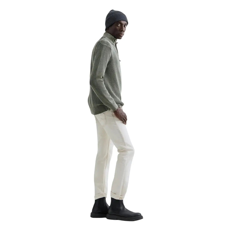Pull en coton Replay pour homme, vert olive côtelé, col zippé, porté par le mannequin avec un pantalon blanc et des bottes noires.