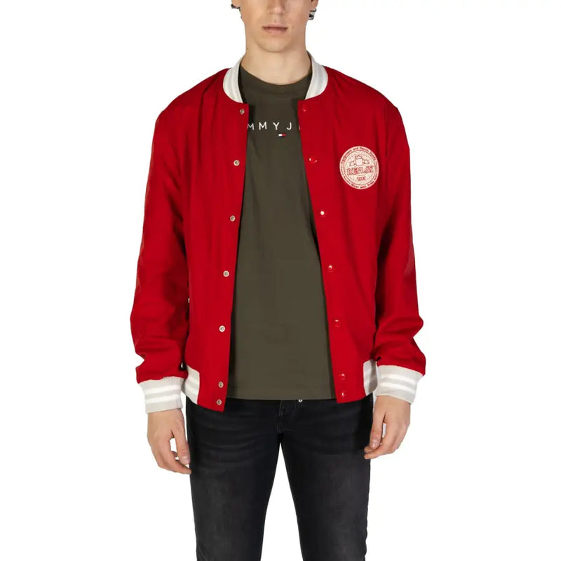 Veste universitaire rouge Tommy Hilfiger avec bordures blanches et logo rond, portée avec un blazer Replay pour homme à poches zippées rouges.