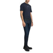 Dark blue slim fit jeans with a subtle distressed texture and black leather shoes.