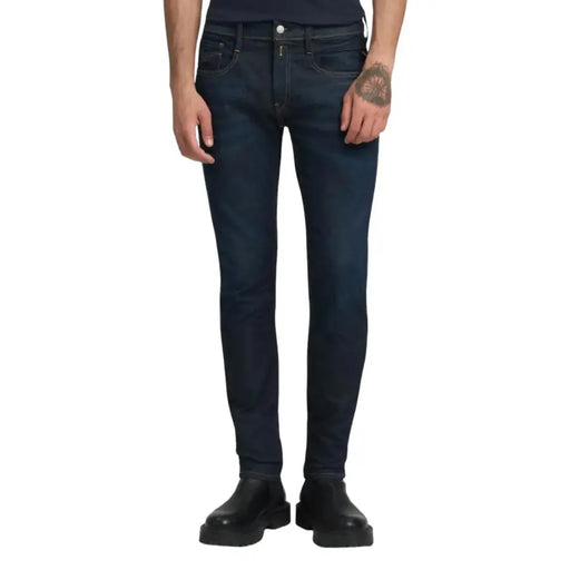 Dark blue slim fit jeans with a distressed look and button fly design.