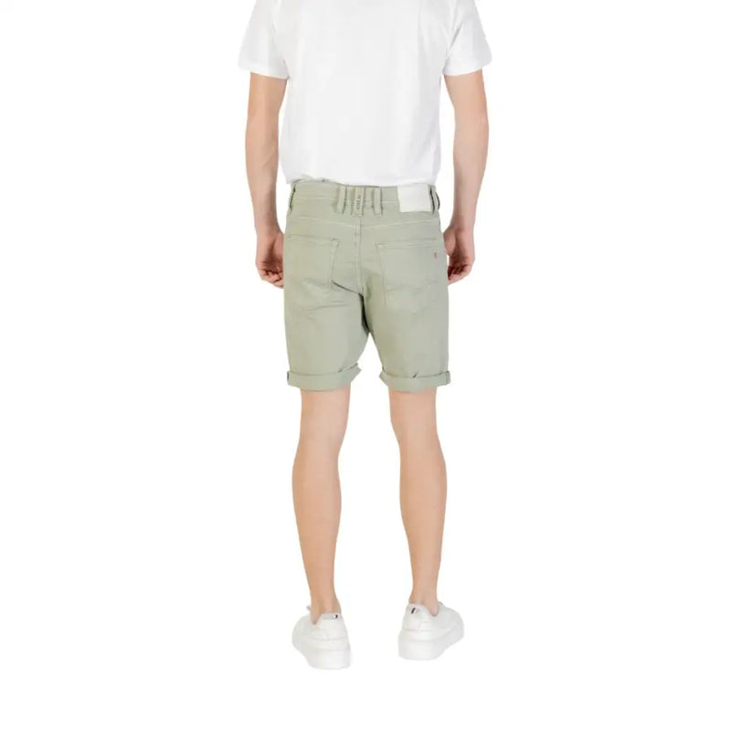 Light green chino shorts with rolled hem and elastic waistband, suitable for casual wear.