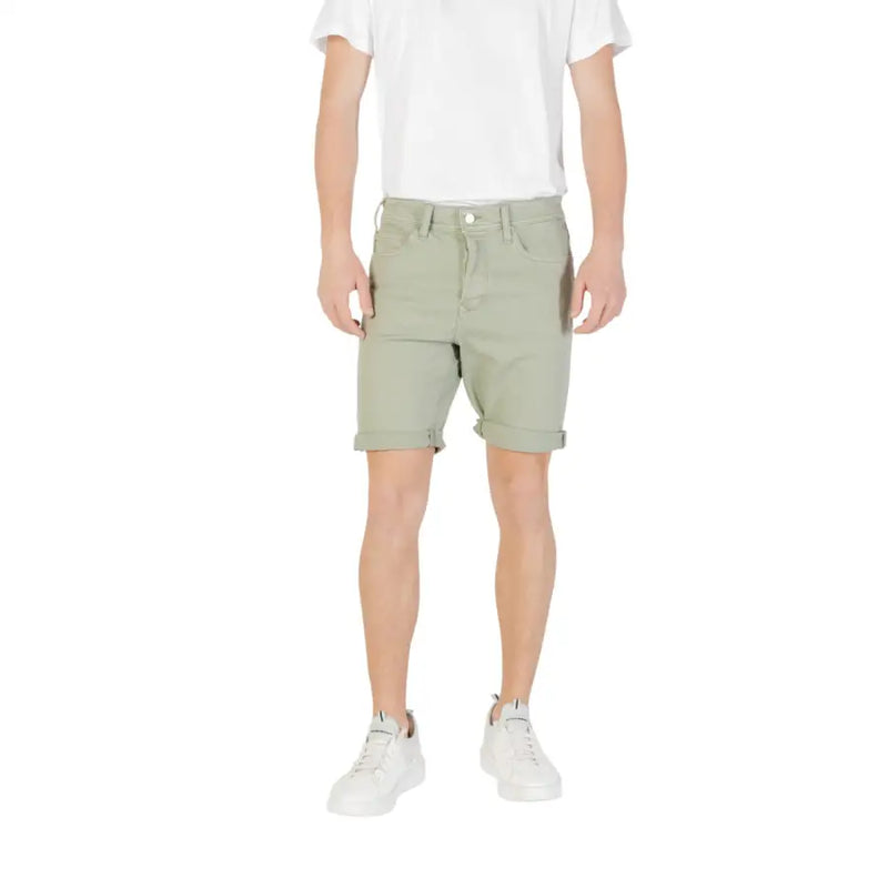 Olive green cotton shorts with rolled hem and button fly design.