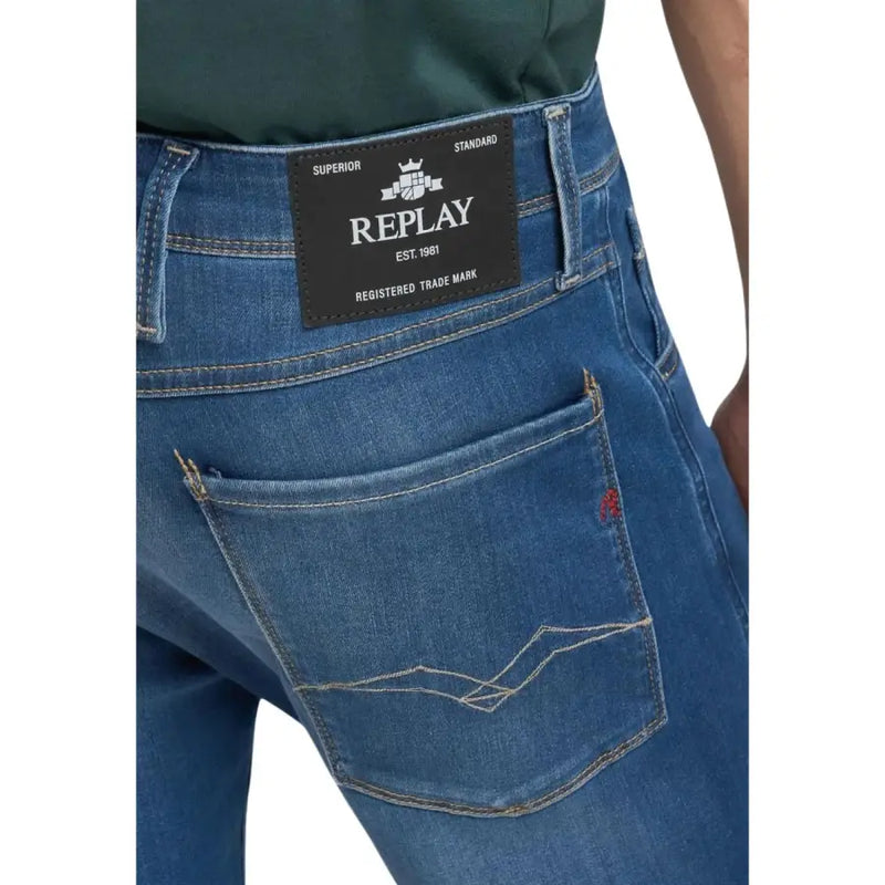Vue arrière d'un jean slim bleu pour homme, marque Replay, avec étiquette noire et surpiqûres blanches sur la poche arrière.