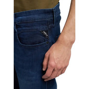 Jean homme Replay bleu, coupe slim, fermeture éclair, en denim bleu foncé légèrement délavé, avec étiquette de la marque (recto).