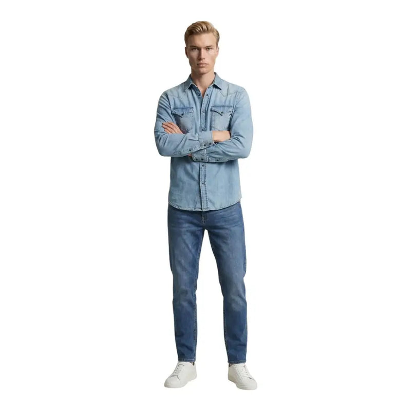 Chemise homme Replay en denim clair avec deux poches poitrine et fermeture boutonnée, portée avec un jean bleu foncé