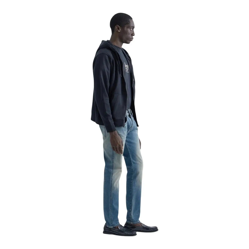 Jean slim Replay Anbass pour homme en denim bleu clair, porté par un mannequin avec un sweat à capuche zippé bleu marine (vue de face)