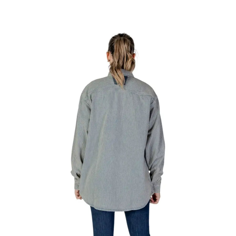 A woman wearing a replay women pinstripe long-sleeved button-up shirt in blue and gray for spring summer