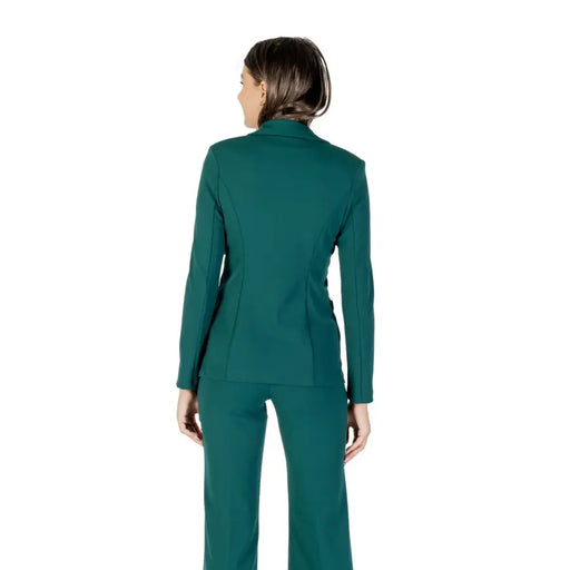 A woman wearing a dark teal pantsuit from Rinascimento Long Green V Neck Women Blazer for Fall Winter