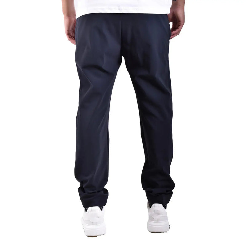 Pantalon homme en polyamide bleu marine foncé, coupe fuselée, dos dévoilant le tissu lisse et brillant avec des plis discrets.