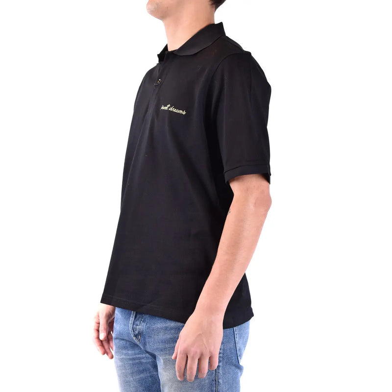 Polo Saint Laurent en coton noir pour homme, orné d'une broderie dorée « Just Dreams » sur la poitrine gauche, vue de face