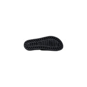 Semelle en caoutchouc noir des pantoufles Sensi pour hommes, modèle La Jolla Urban, bout ouvert en PVC noir avec rainures texturées et logo de la marque en relief.