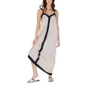 A flowing off-white sleeveless floor length dress with sleek black trim along neckline sides and hem