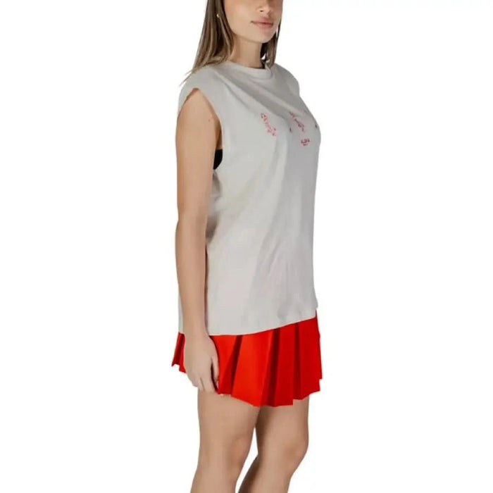 Sleeveless gray tank top paired with red pleated skirt in stylish outfit display