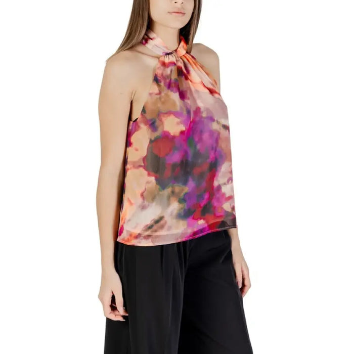 Sleeveless halter top with colorful abstract pattern paired with Black Pants in product display