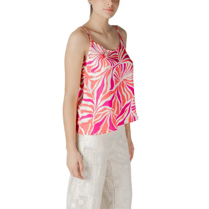 Sleeveless pink and orange patterned camisole worn with white pants in the Floral Print Camisole and White Pants set