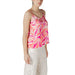 Sleeveless pink and orange patterned camisole worn with white pants in the Floral Print Camisole and White Pants set