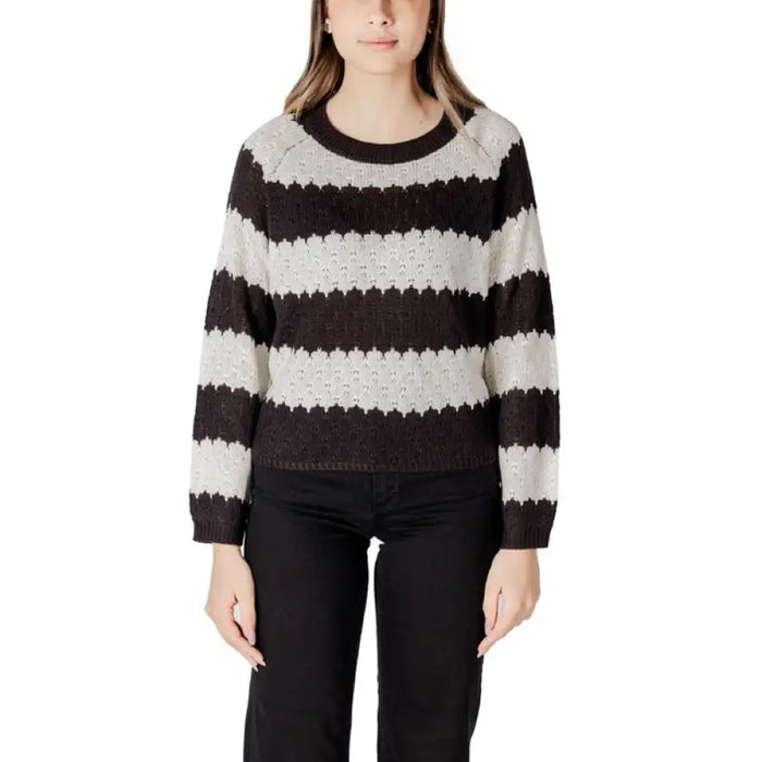Women’s striped knit sweater paired with black pants for a stylish look