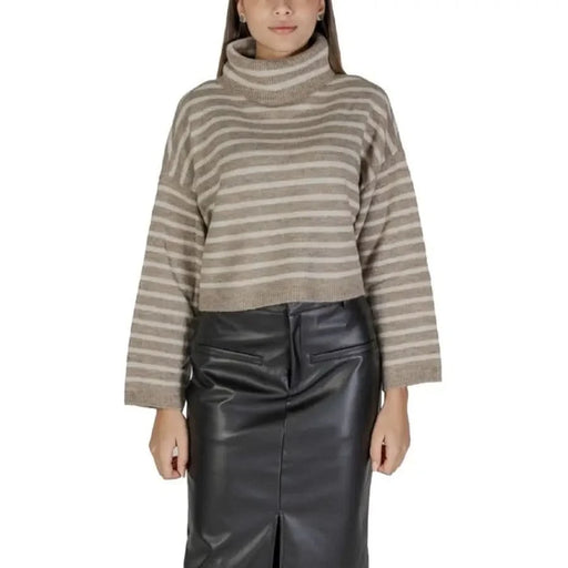 Beige striped turtleneck sweater paired with a black skirt for women’s fall and winter fashion