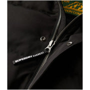 Tirette de fermeture éclair pour doudoune Superdry Everest noire avec inscription blanche, sur une longue veste d'hiver à capuche pour homme, référence M5011743a