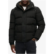 Superdry Doudoune longue noire à capuche pour homme, style hivernal, avec capuche doublée à carreaux, fermeture boutonnée et design matelassé.