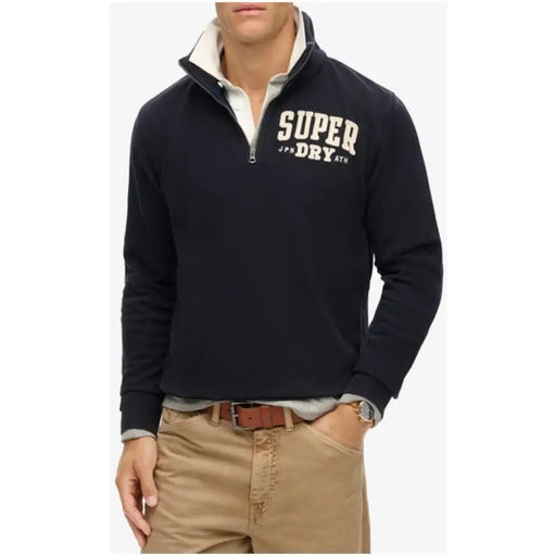 Sweat-shirt Superdry noir pour homme, à demi-zip, en polaire, avec inscription crème et col intérieur en coton gris clair.