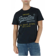 Superdry T-shirt homme vintage en coton noir avec imprimé graphique gris et or, col rond, modèle M1012212A