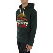Superdry men’s green hooded sweatshirt with front pockets featuring a retro sun and mountain graphic in orange red and white