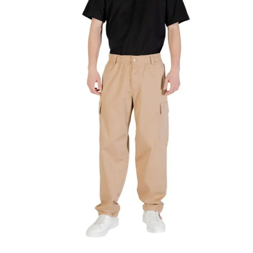 Chemise bleu clair pour homme associée à un pantalon cargo beige, présentée sur le présentoir de produit.