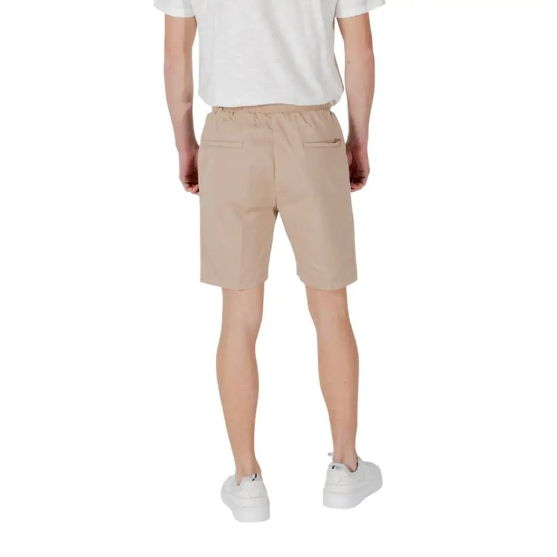 Beige cotton tan drawstring shorts shown from the back with a drawstring waist and two back pockets