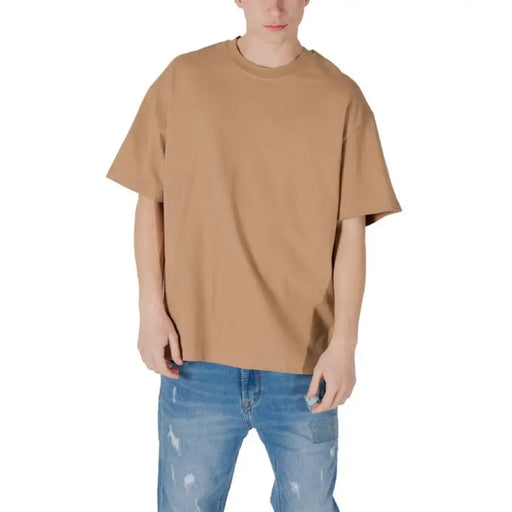 Tan oversized t-shirt paired with blue jeans, casual fashion outfit