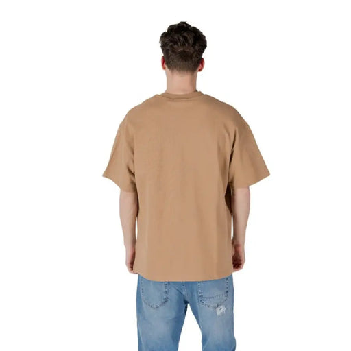 Tan oversized T-shirt paired with classic blue jeans displayed in product image