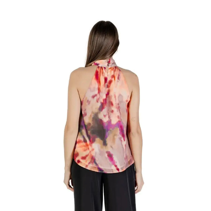 Tie-neck sleeveless floral halter top paired with black pants in a stylish outfit scene