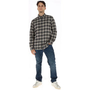Un homme portant un Timberland Chemise à carreaux en coton noir et blanc pour homme, à porter avec un jean bleu foncé