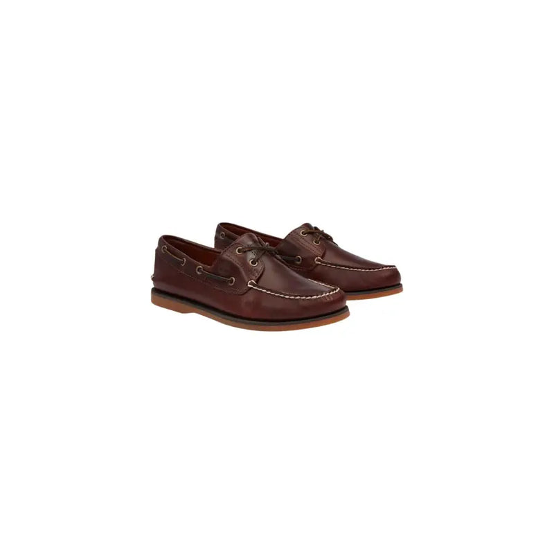 Timberland Mocassins bateau en cuir marron pour homme, avec surpiqûres blanches contrastantes et lacets foncés.