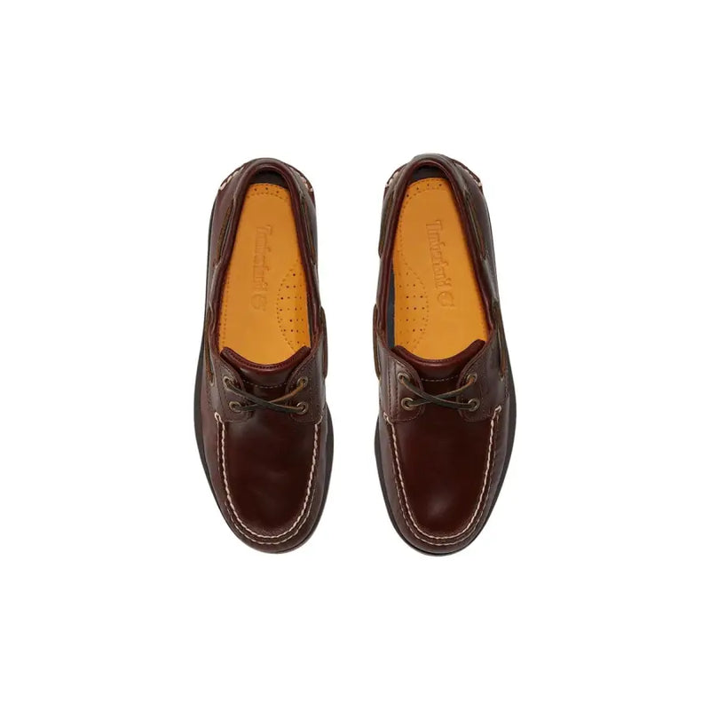 Timberland Mocassins en cuir marron pour homme, style bateau, avec surpiqûres blanches contrastantes et semelles intérieures beiges.