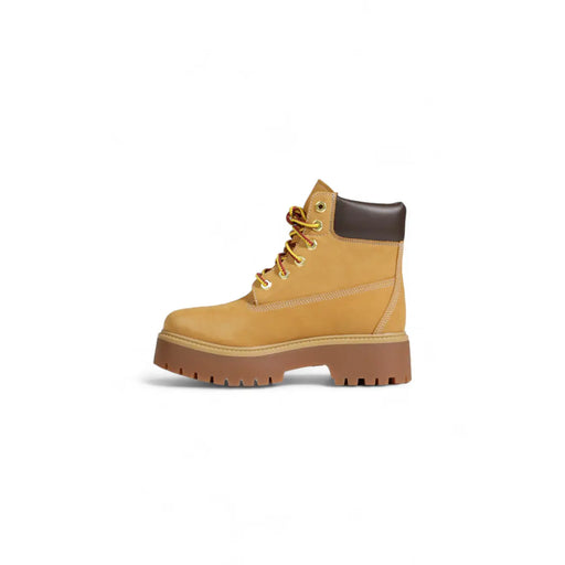 Timberland Bottines en cuir beige à lacets pour femmes, avec semelle et talon en cuir fauve et caoutchouc marron visibles à l'arrière.