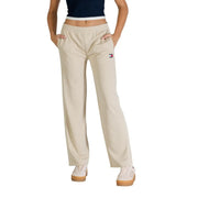 Pantalon de survêtement beige Tommy Hilfiger avec bandes latérales blanches et petit logo sur la cuisse gauche, idéal pour la collection printemps-été femme.