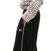 Black tommy hilfiger womens spring summer track pants with white side stripes and logo patch on thigh