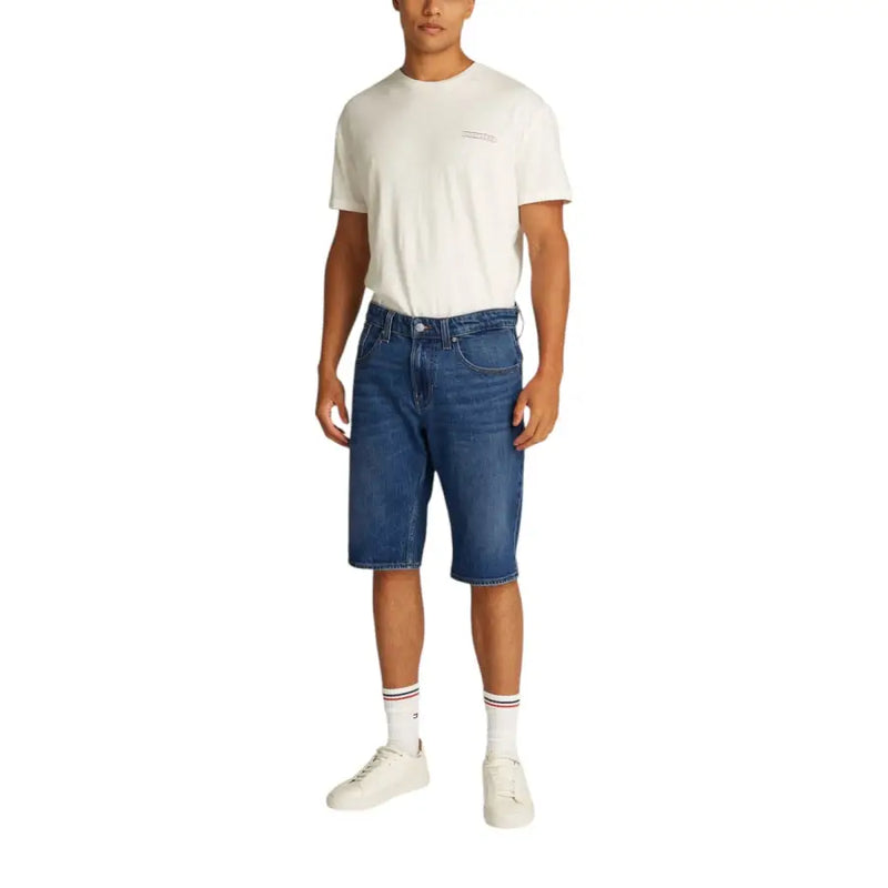 Blue denim shorts with white socks and a cream t-shirt.