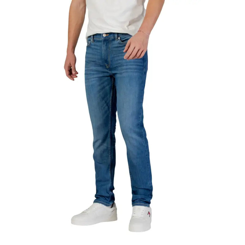 Blue denim jeans with white sneakers and a white t-shirt.